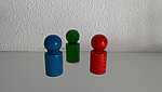 Auf dem Bild sind drei Spielfiguren in den Farben blau, grün und rot abgebildet. 