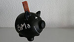Auf dem Bild ist ein schwarzes Sparschwein mit der Aufschrift "BiMa" abgebildet.
