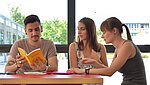 drei Studierende lernen gemeinsam an einem roten Tisch.