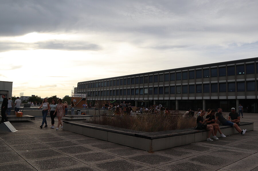 Menschen sitzen abends auf dem Campus der PH