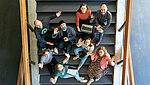 Das Bild wurde am Forschungstag aufgenommen und zeigt einige Studierende auf einer Treppe sitzend.