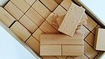verschiedene Holzklötze in der Schachtel als Symbol des Seminars Mathematik im Anfangsunterricht