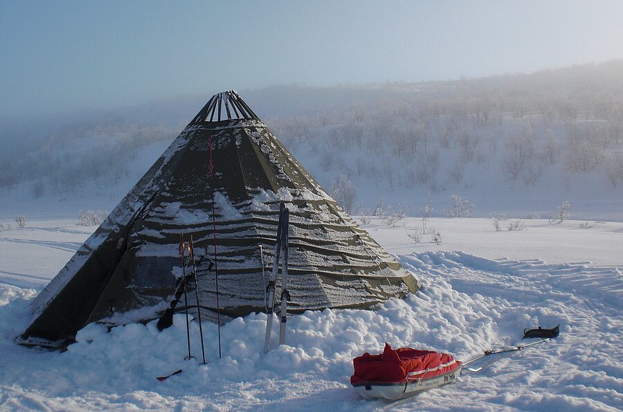 Zelt im Schnee mit Schlitten