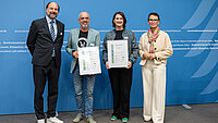 Ehrung der P&auml;dagogischen Hochschule Ludwigsburg und der Hochschule Magdeburg-Stendal auf dem gemeinsamen 3. Platz der &bdquo;Recyclingpapierfreundlichsten Hochschulen&ldquo; 2026, v.l.n.r.: Marc Gebauer (Sprecher der Initiative Pro Recyclingpapier), Prof. Dr. J&ouml;rg-U. Ke&szlig;ler (Rektor der P&auml;dagogischen Hochschule Ludwigsburg), Nora K&uuml;ster-Dammaschke (Kanzlerin der Hochschule Magdeburg-Stendal) und Parlamentarische Staatssekret&auml;rin Rita Schwarzel&uuml;hr-Sutter 