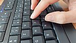 Ausschnitt der Hand einer Person, die an der Tastatur arbeitet.
