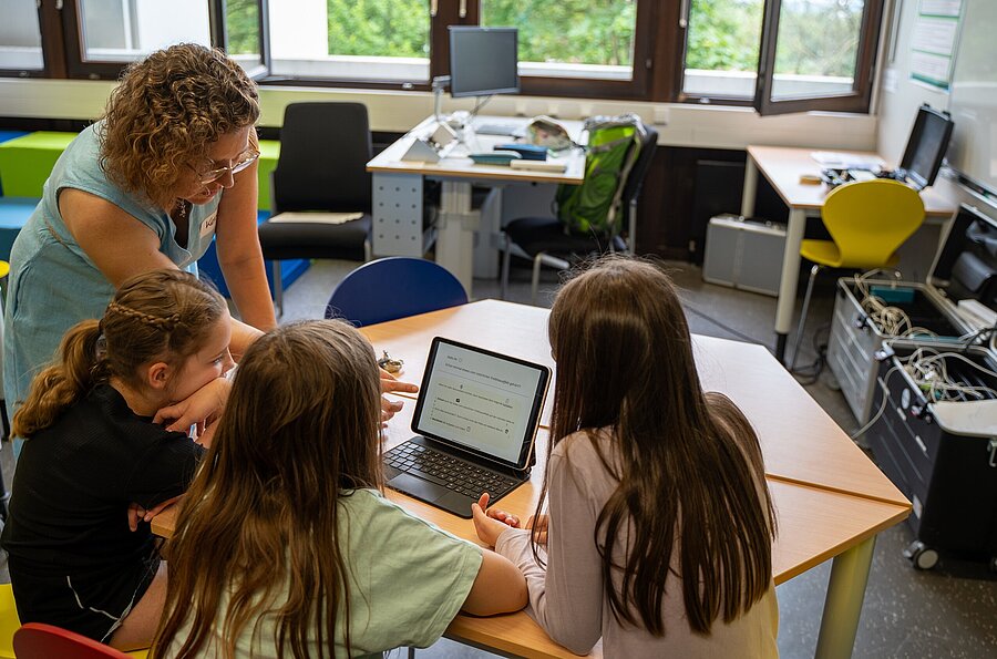 Um einen Tisch sitzende Schüler*innen arbeiten mi t einem Laptop im Rahmen eines Workshops beim Lernfestival der PH Ludwigsburg.