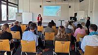 Zu sehen ist Prof.in. Susan Harris-Huemmert, wie Sie ihren Vortrag im Namen des AGICA Teams bei der Internationalen Tagung hält.