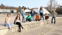 Studierende sitzen am Brunnen