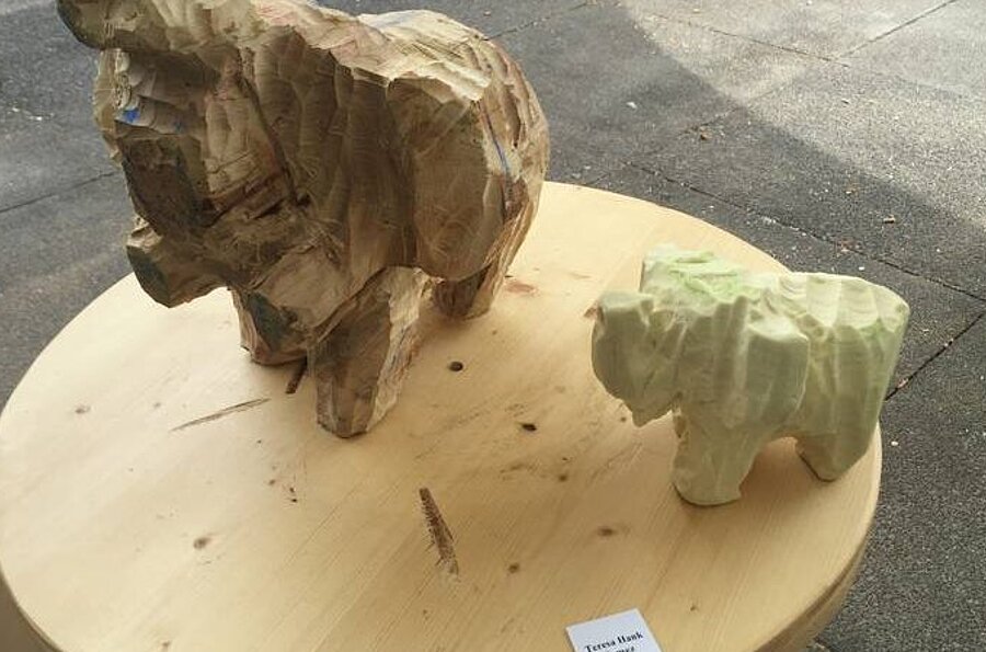 Ein aus Holz geschlagener Elefant und ein Vor-Modell dazu aus Seife. 