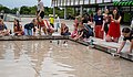 Kinder sitzen um den Brunnen der PH Ludwigsburg und lassen selbstgebasteltete Boote ins Wasser