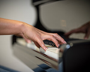 Nahaufnahme einer Hand am Klavier