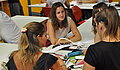 Drei Frauen sitzen an einem Tisch und diskutieren