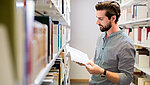 Student liest Buch in Uni-Bibliothek
