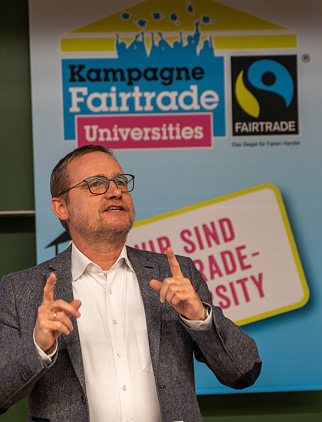Holger Heß bei Rede vor Fairtade University Fahne