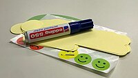 Ein Filzstift liegt auf Post-Its und Klebesmileys