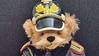 Teddybär mit Pickelhaube und Uniform.