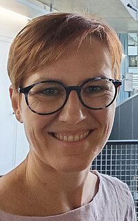 Man sieht eine Frau im Profil mit Brille.