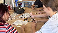 Studierende und Mitarbeitende probieren ein EscapeGame aus