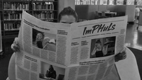 Eine Person liest Zeitung in der Bibliothek der PH.