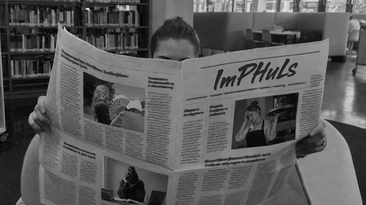 Eine Person liest Zeitung in der Bibliothek der PH.